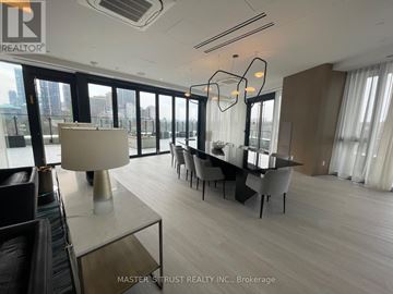 Toronto (North St. James Town) condo for rent - A modern living room with a dining table and chairs, a sofa, and a large window with a city view.