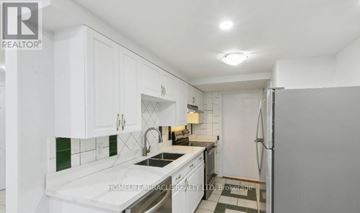 Ajax (Central West) apartment for rent - A white kitchen with a sink, stove, and refrigerator.