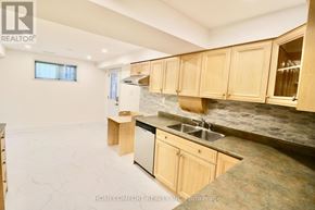 Toronto (L'amoreaux) apartment for rent - A kitchen with wooden cabinets and a stone countertop.