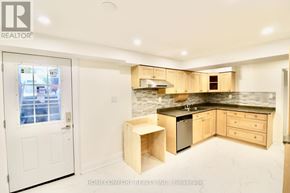 Toronto (L'amoreaux) apartment for rent - A modern kitchen with wooden cabinets and a black countertop.