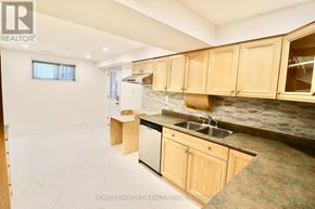 Toronto (L'amoreaux) apartment for rent - A kitchen with wooden cabinets and a marble countertop.