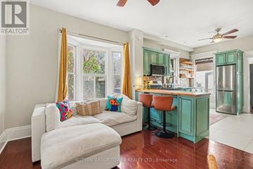 Toronto (Junction Area) apartment for rent - A living room with a white couch and a kitchen area in the background.