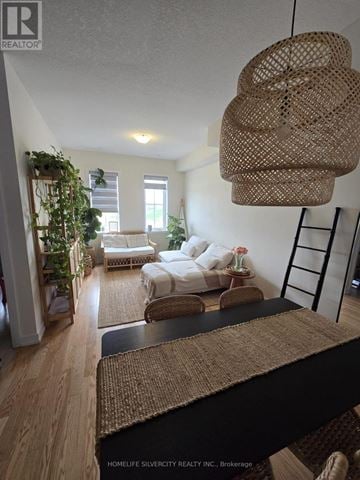 Brantford townhouse for rent - A living room with a white couch and a woven hanging light fixture.