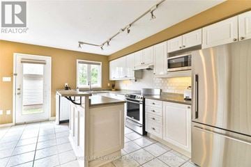 Oakville (Ro River Oaks) apartment for rent - A kitchen with white cabinets and a stainless steel refrigerator.