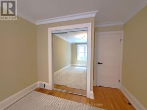 Toronto (The Beaches) triplex for rent - A room with a mirror door leading to another room.