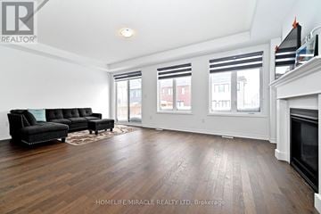 Innisfil apartment for rent - A living room with a black couch and a fireplace.