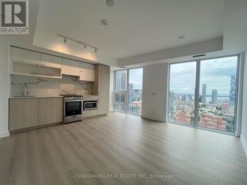 Toronto (Church-Yonge Corridor) condo for rent - A spacious kitchen with wooden floors and a large window overlooking the city.