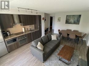 Toronto (Waterfront Communities) condo for rent - A living room with a grey couch and a wooden coffee table.