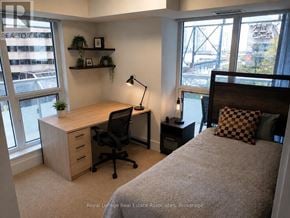 Toronto (Waterfront Communities) condo for rent - A bedroom with a bed, desk, and chair.