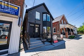 Whitchurch-Stouffville (Stouffville) apartment for rent - A black building with a glass door and windows is in front of a red brick building.