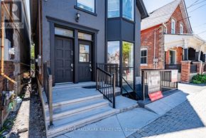 Whitchurch-Stouffville (Stouffville) apartment for rent - A house with a black front door and a red mat on the steps.