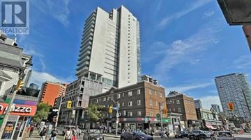 Toronto (Church-Yonge Corridor) condo for rent - A city street scene with a tall building in the background.