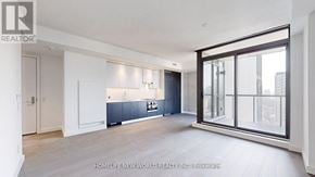 Toronto (Church-Yonge Corridor) condo for rent - A spacious, well-lit kitchen with dark blue cabinets and a large window.