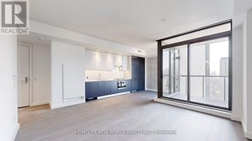 Toronto (Church-Yonge Corridor) condo for rent - A spacious, well-lit kitchen with dark blue cabinets and a large window.