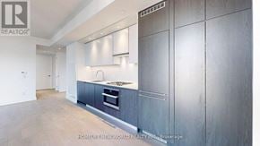 Toronto (Church-Yonge Corridor) condo for rent - A modern kitchen with dark wood cabinets and a stainless steel oven.