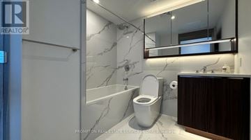 Toronto (Bayview Village) condo for rent - A white toilet with a marble wall behind it.