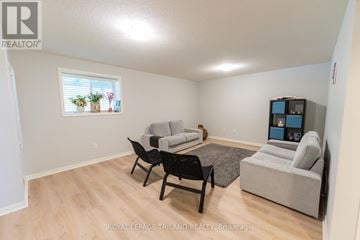 London North (North E) townhouse for rent - A living room with a grey couch, a black chair and a TV.