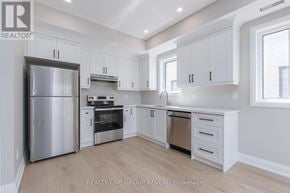 Oshawa (Vanier) triplex for rent - A modern kitchen with white cabinets and stainless steel appliances.