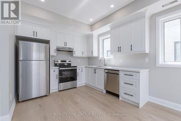 Oshawa (Vanier) apartment for rent - A modern kitchen with white cabinets and stainless steel appliances.