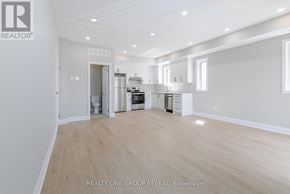 Oshawa (Vanier) triplex for rent - A spacious, empty room with light wood flooring and white walls.