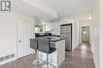 London East (East L) duplex for rent - A kitchen with white cabinets and a black countertop.