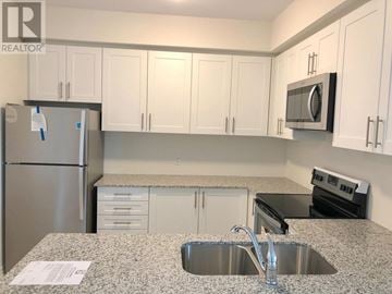 Oakville (Wm Westmount) townhouse for rent - A kitchen with a sink, refrigerator, and microwave.