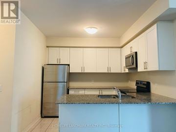 Oakville (Wm Westmount) townhouse for rent - A kitchen with white cabinets and a granite countertop.