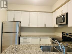 Oakville (Wm Westmount) townhouse for rent - A kitchen with white cabinets and a granite countertop.
