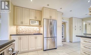 Toronto (Banbury-Don Mills) apartment for rent - A kitchen with a stainless steel refrigerator and wooden cabinets.