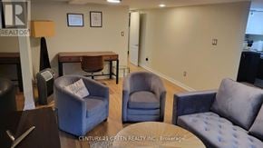Toronto (High Park-Swansea) apartment for rent - A realtor's office with a sign on the wall and a couch in the foreground.