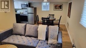 Toronto (High Park-Swansea) apartment for rent - A living room with a grey couch and a dining table.