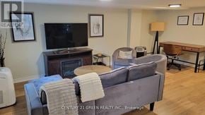 Toronto (High Park-Swansea) apartment for rent - A living room with a grey couch, a television, and a wooden table.