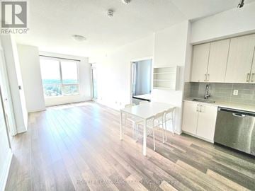 Toronto (Tam O'shanter-Sullivan) condo for rent - A kitchen with a white table and chairs and a stainless steel refrigerator.