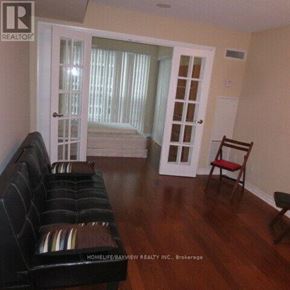 Toronto (Bay Street Corridor) condo for rent - A living room with a black couch and a wooden floor.