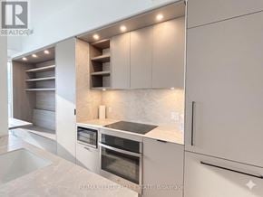 Toronto (Church-Yonge Corridor) townhouse for rent - A modern kitchen with white cabinets and a marble countertop.
