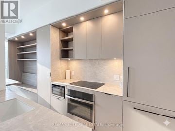 Toronto (Church-Yonge Corridor) townhouse for rent - A modern kitchen with white cabinets and a marble countertop.