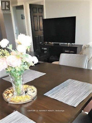 Richmond Hill (Langstaff) condo for rent - A living room with a wooden table and a television.