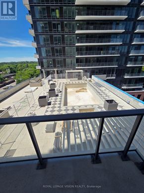 Toronto (Humber Heights) condo for rent - A view of a courtyard from a balcony with a glass railing.