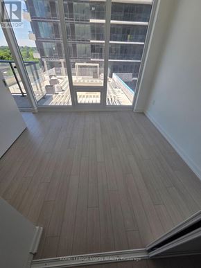 Toronto (Humber Heights) condo for rent - A room with a wooden floor and a glass wall overlooking a pool.