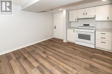 Ottawa apartment for rent - A kitchen with white cabinets and a stove top oven.