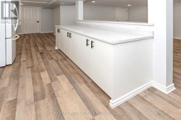 Ottawa apartment for rent - A kitchen with white cabinets and a wooden floor.