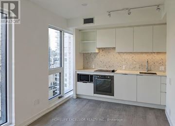 Toronto (Church-Yonge Corridor) condo for rent - A kitchen with white cabinets and a marble backsplash.