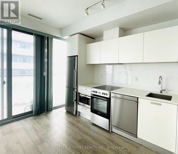 Toronto (Church-Yonge Corridor) condo for rent - A modern kitchen with white cabinets and stainless steel appliances.
