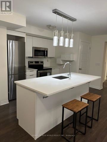 Toronto (Downsview-Roding-Cfb) townhouse for rent - A kitchen with white countertops and a stainless steel refrigerator.