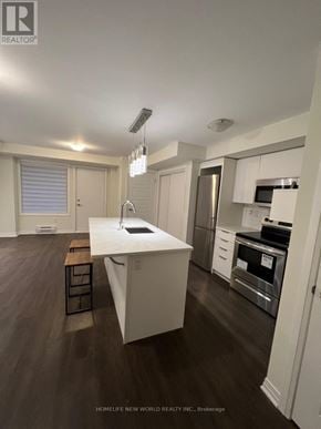 Toronto (Downsview-Roding-Cfb) townhouse for rent - A modern kitchen with a white island and stainless steel appliances.