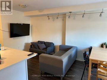Toronto (Downsview-Roding-Cfb) townhouse for rent - A living room with a grey couch and a flat screen TV mounted on the wall.