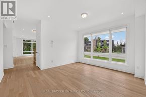 Georgian Bay (Baxter) house for rent - A spacious room with wooden flooring and a large window showing a view of a residential area.