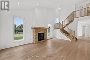 Georgian Bay (Baxter) house for rent - A spacious living room with a fireplace and a staircase.