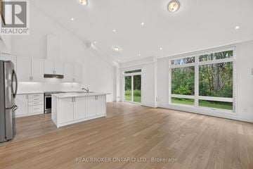 Georgian Bay (Baxter) house for rent - A spacious kitchen with white cabinets and a refrigerator.