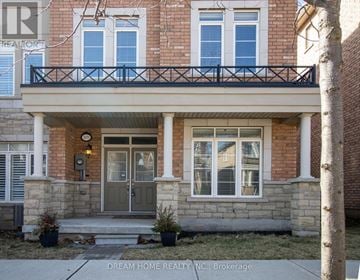 Oakville (Oa Rural Oakville) townhouse for rent - A brick house with a balcony and a front door.